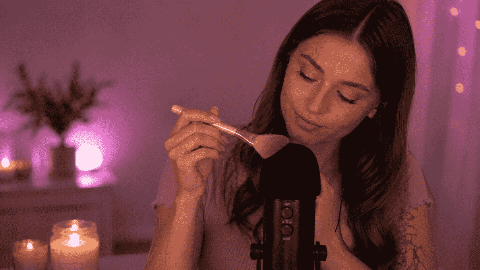 ASMR-Creatorin führt eine Bürste nah am Mikrofon in einer sanft beleuchteten Aufnahmeszene