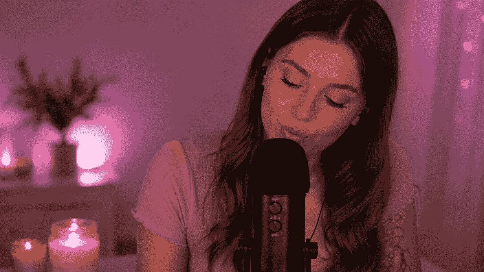 ASMR-Creatorin nah am Mikrofon in einer sanft beleuchteten Aufnahmeszene