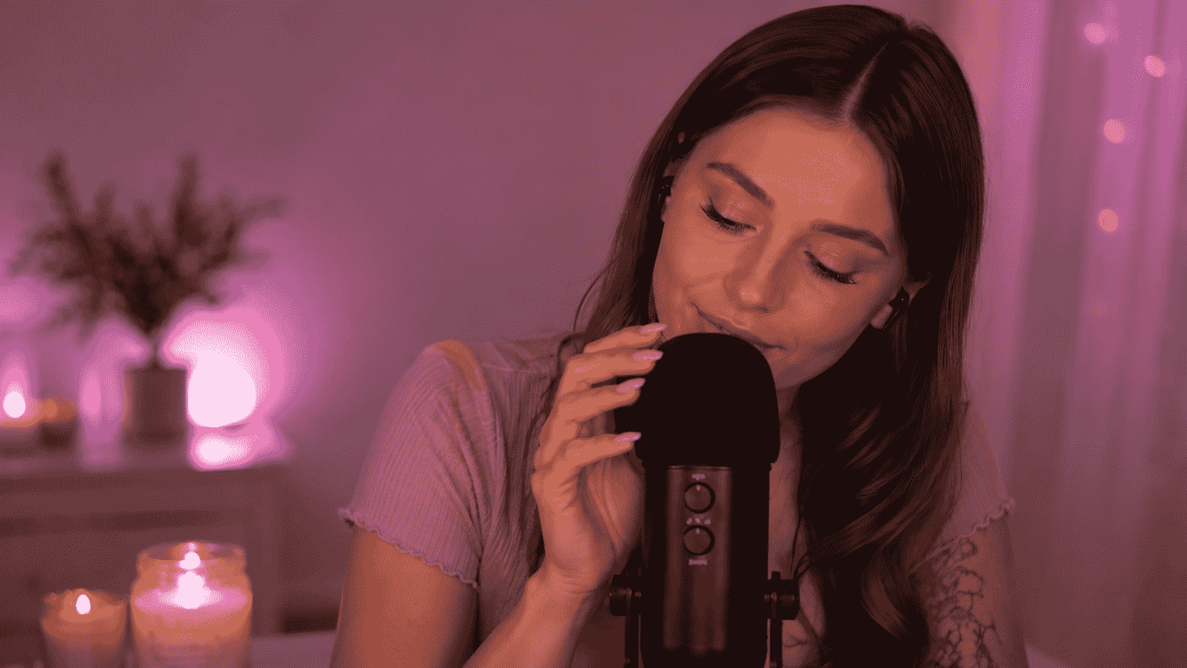 ASMR-Creatorin flüstert in ein Mikrofon in einer sanft beleuchteten Aufnahmeszene